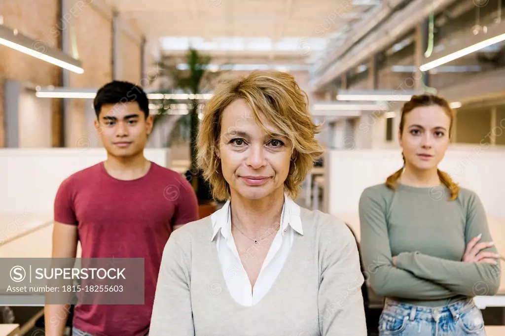 Male and female professional standing in coworking office