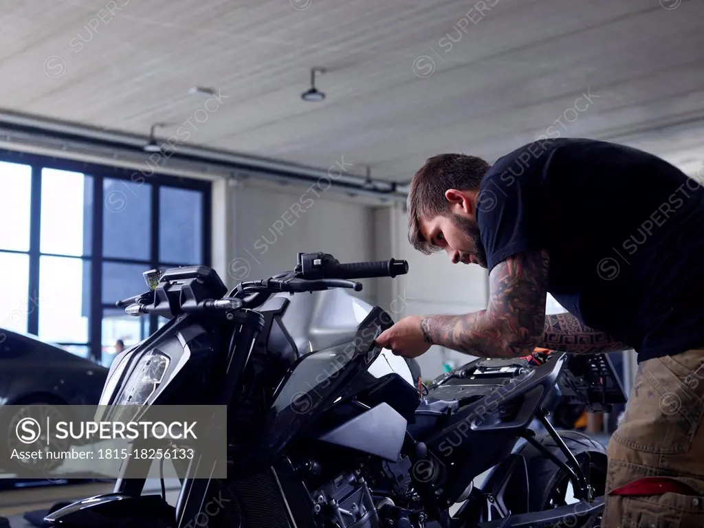 Maintenance engineer repairing vehicle seat at auto repair shop