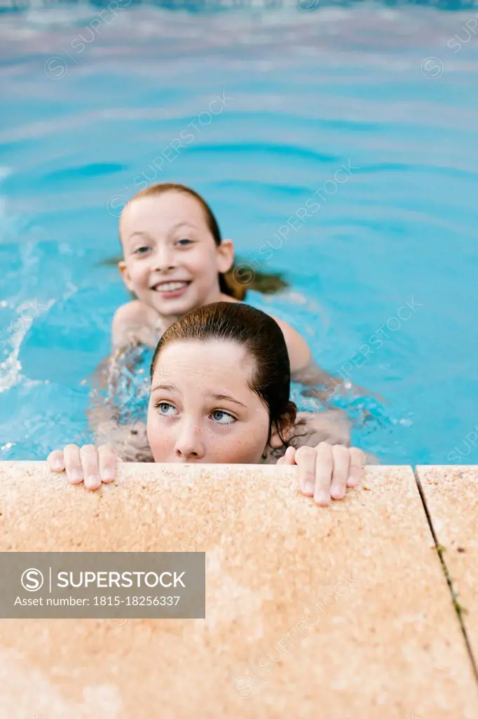 Siblings playing in swimming pool together