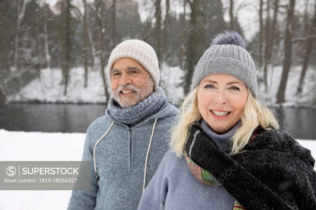 Smiling senior woman with man at park during winter