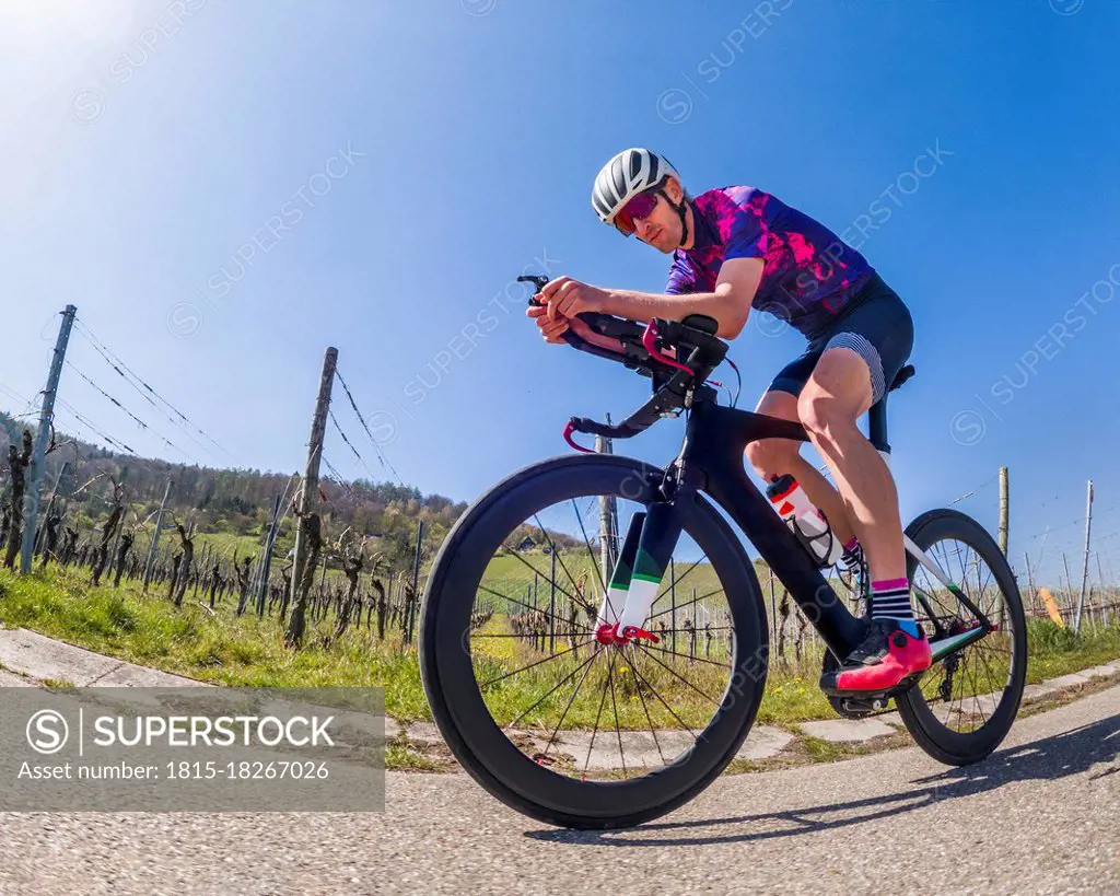 Active man riding racing bicycle on road