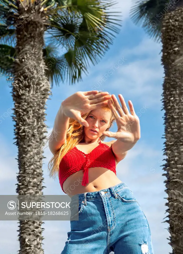 Young woman gesturing during sunny day