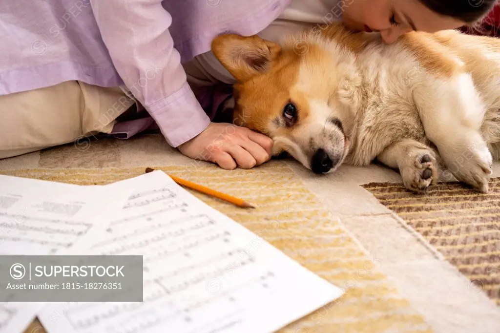 Mid adult woman kissing relaxed dog at home