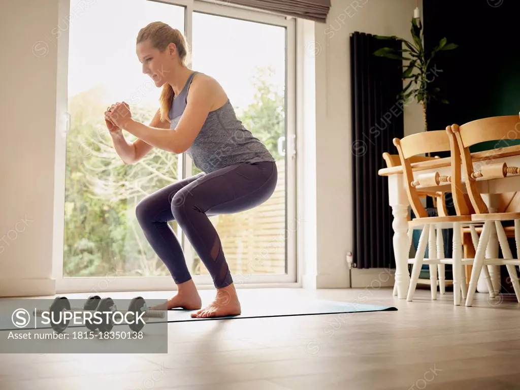 Active woman practicing squats at home