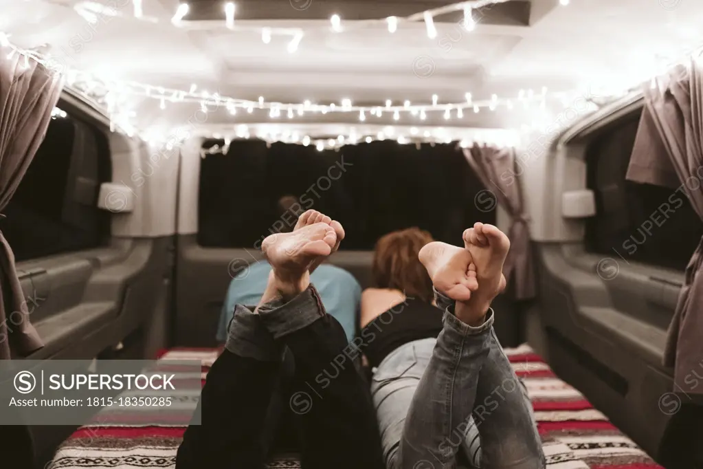 Mid adult couple lying in illuminated van