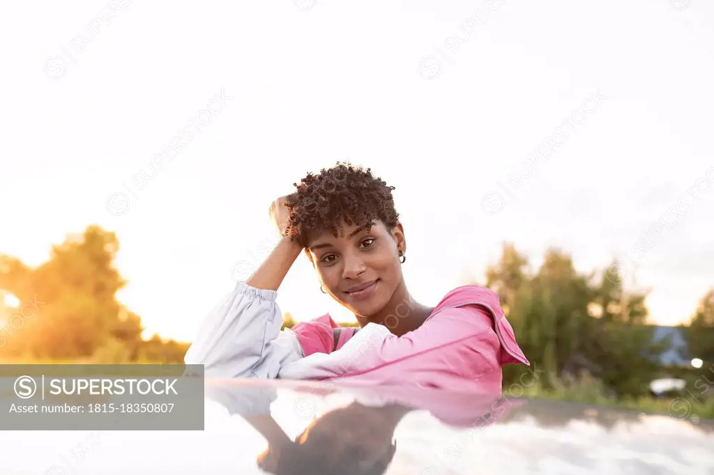 Young woman with head in hand on car outdoors