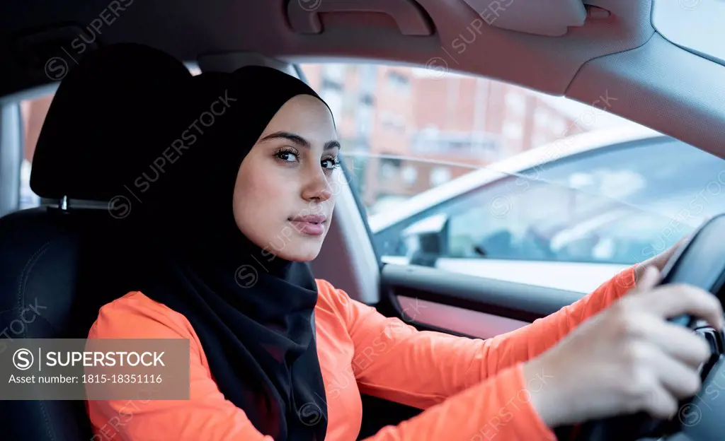 Thoughtful Arab woman looking away while driving car