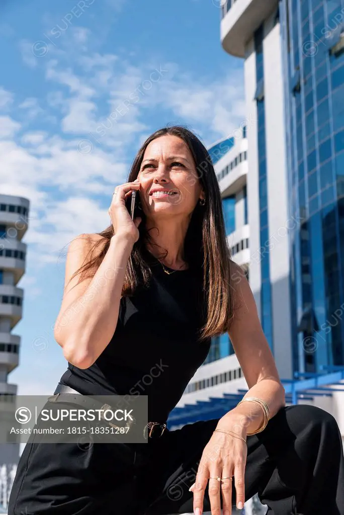 Businesswoman talking on mobile phone during sunny day