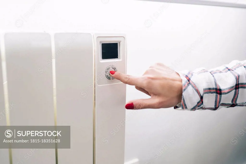 Woman operating heating at home