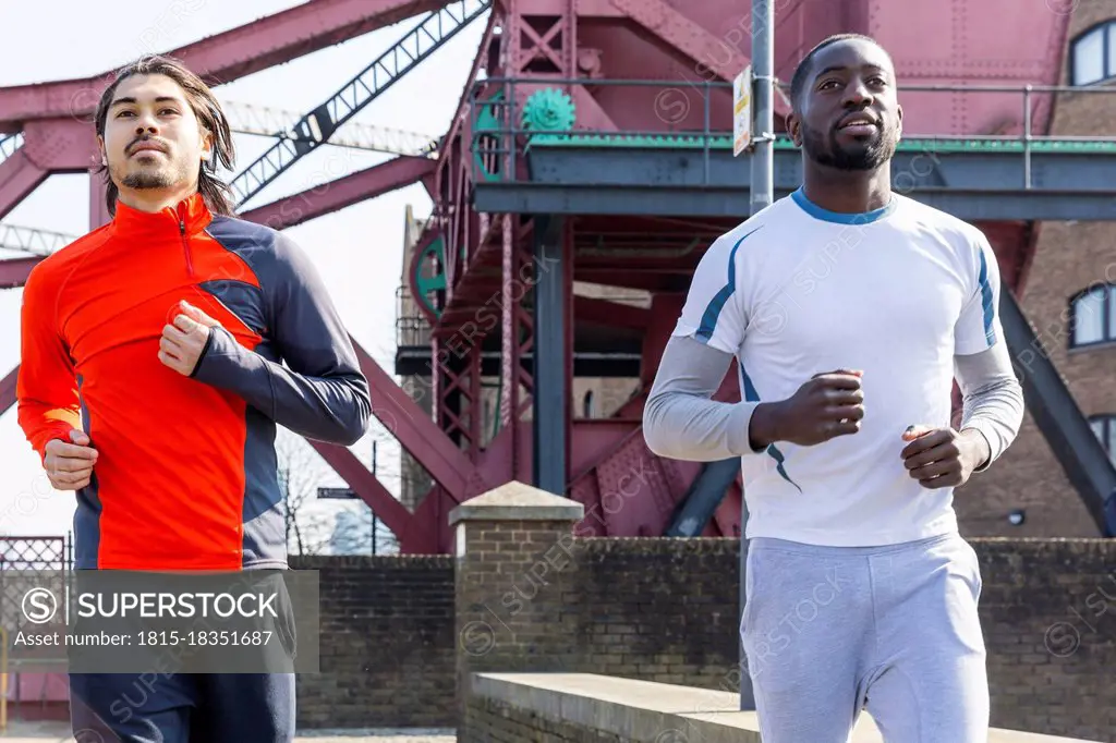 Men running together on sunny day