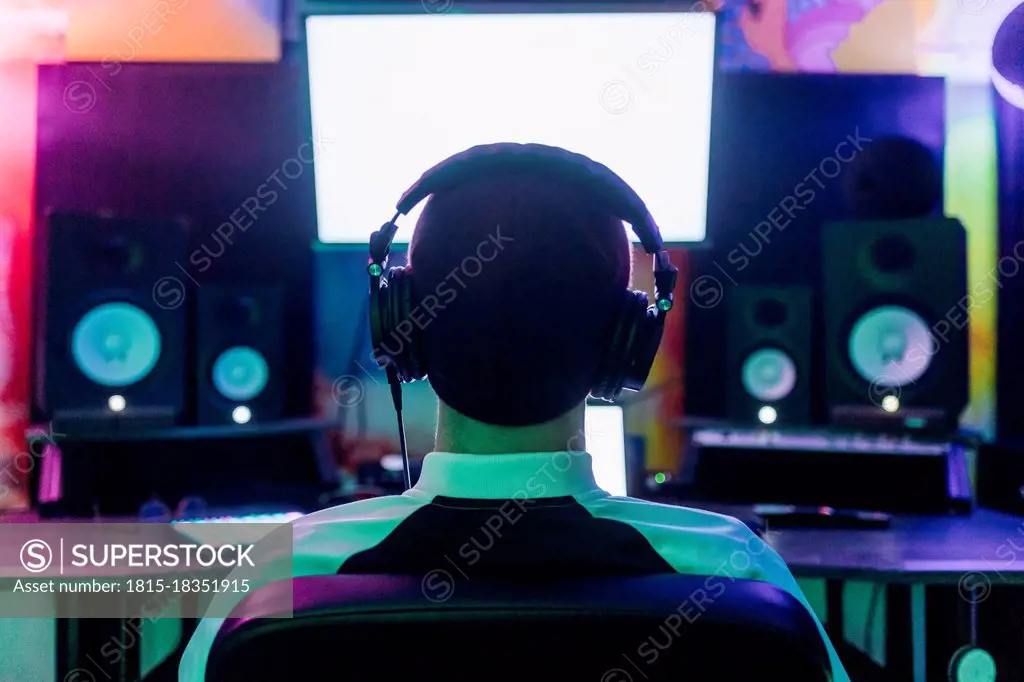 Male composer listening music while composing at home studio