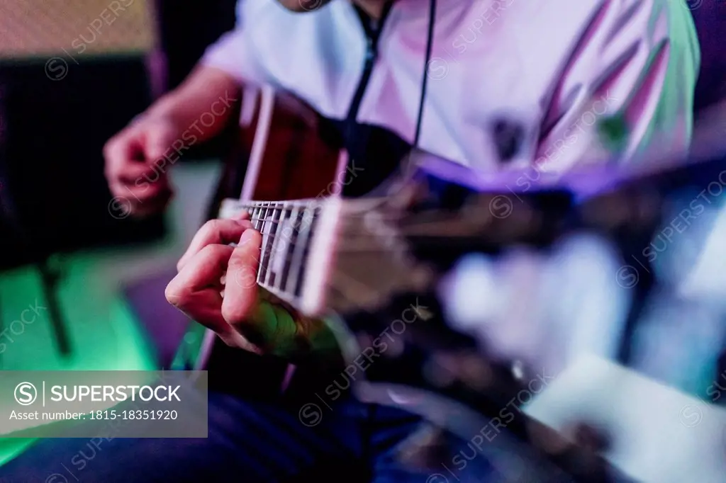 Male guitarist composing music at studio