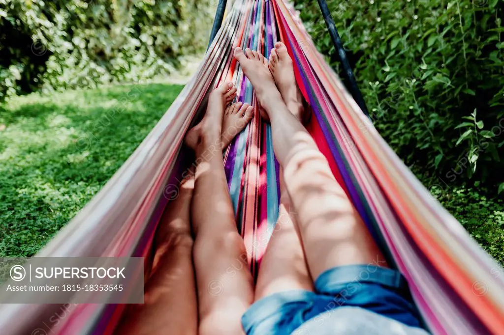 Girls lying in hammock on sunny day