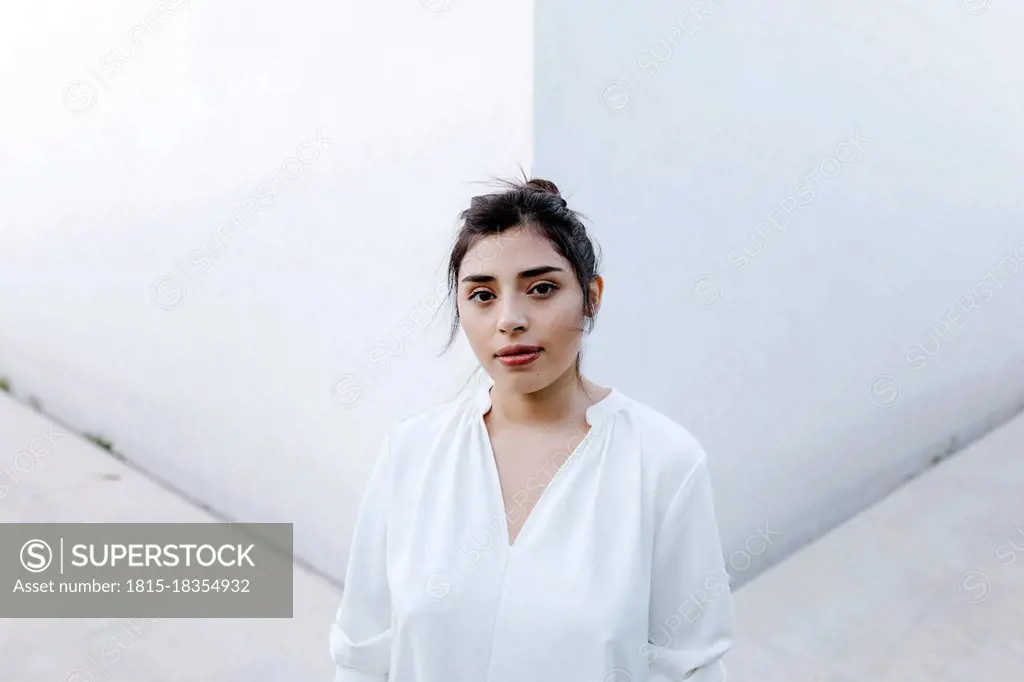 Young woman standing in front of white wall