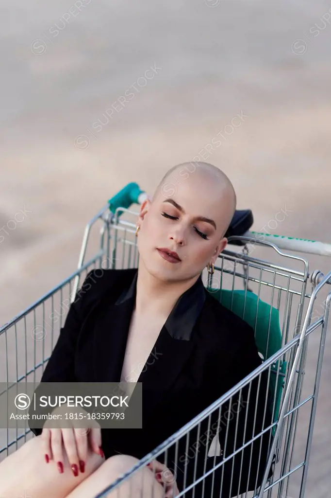 Bald transgender woman sleeping in shopping cart