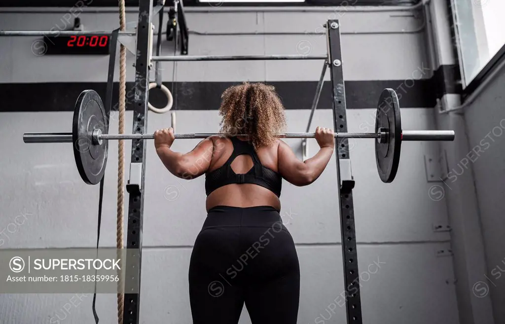 Woman practicing weight lifting in gym