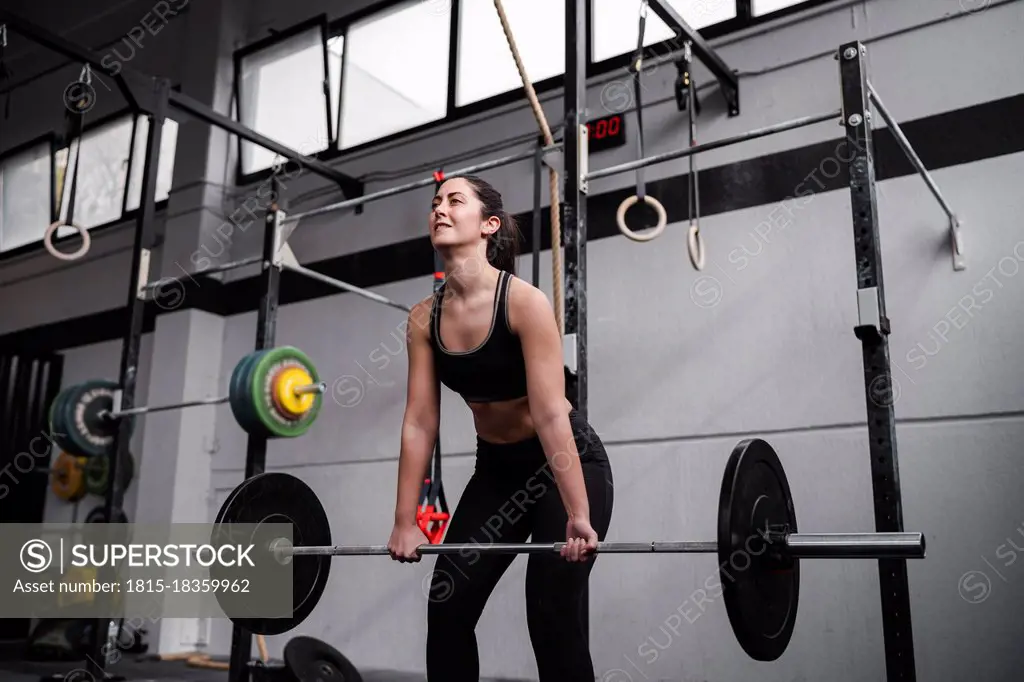 Active woman lifting weight in gym