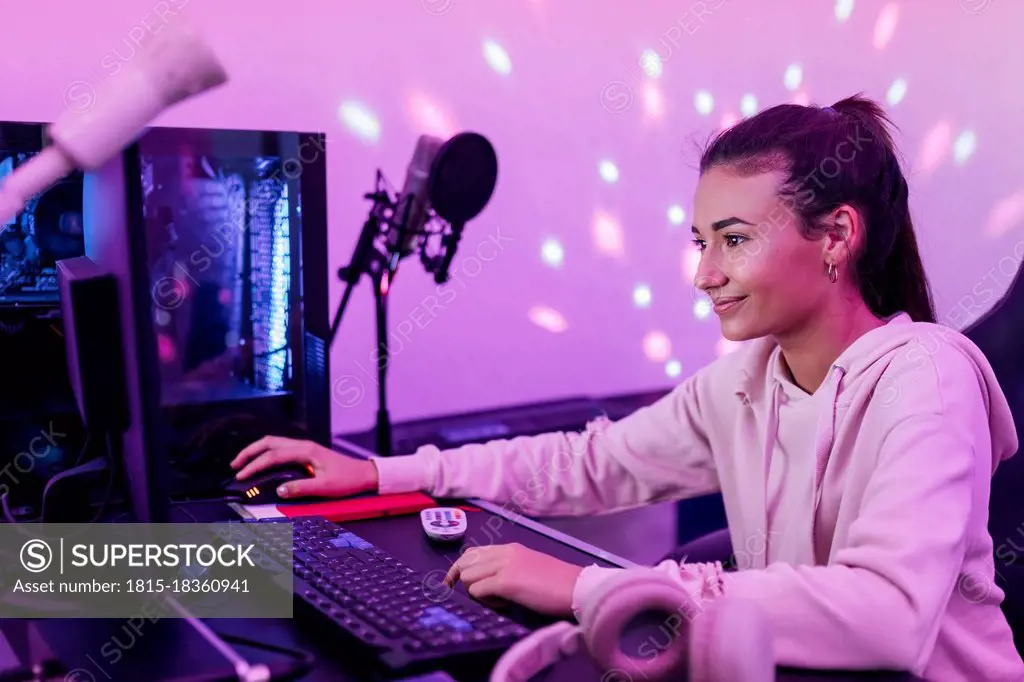 Smiling female singer using computer in studio