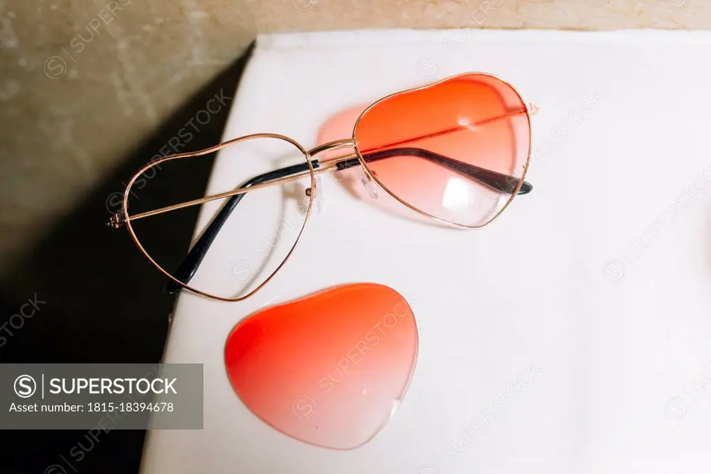 Broken orange heart shape sunglasses on table