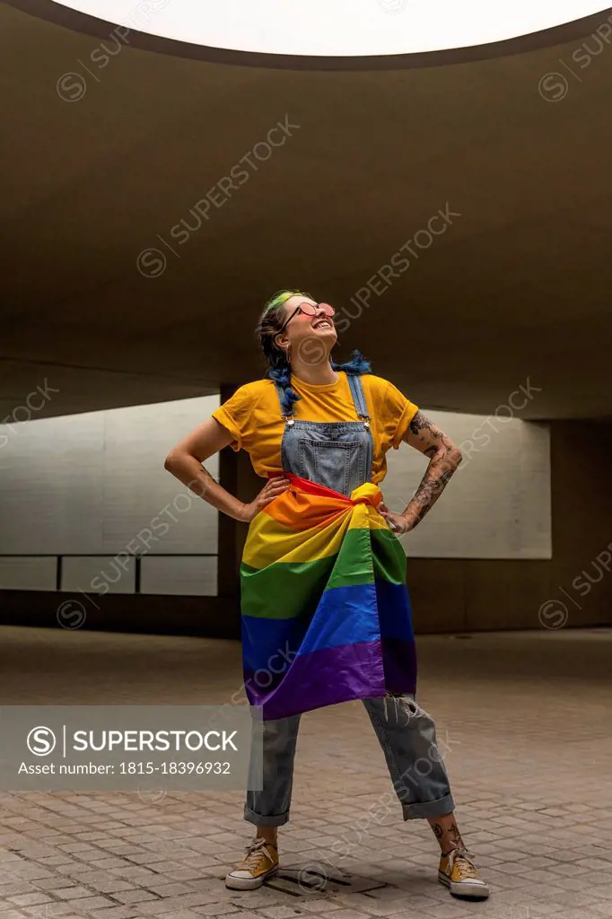 Woman looking up with rainbow flag tied around waist