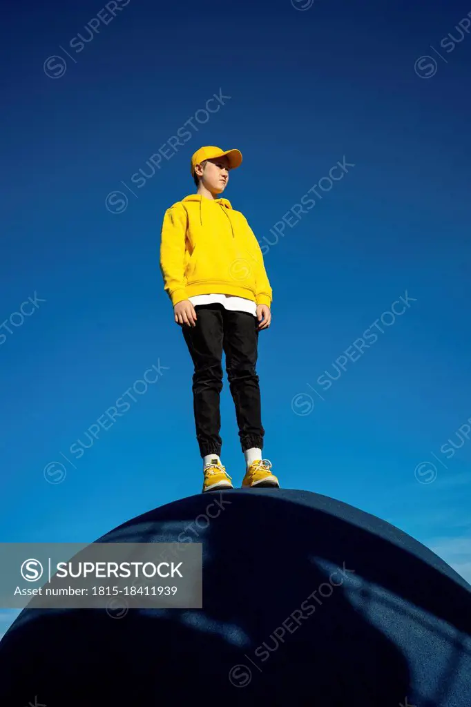 Boy looking away while standing at skateboard park