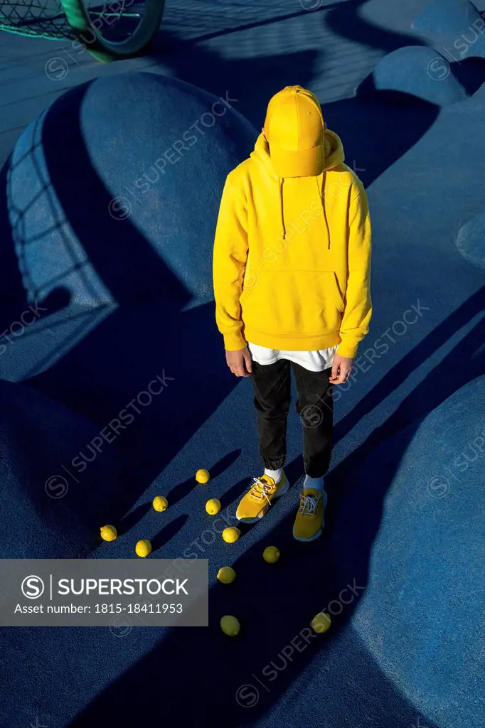 Boy standing amidst lemons at skateboard park