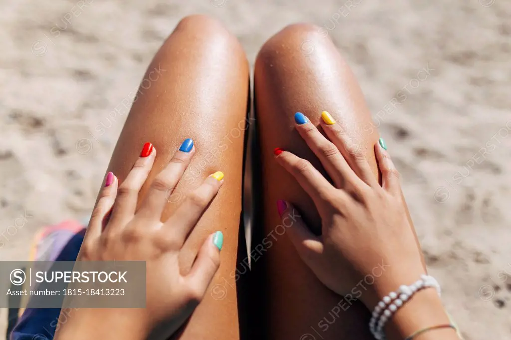 Woman with colorful nail polish enjoying sunny day at beach