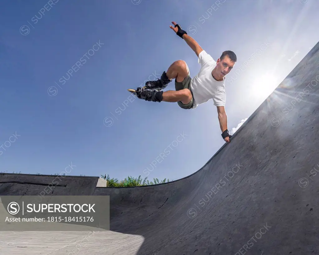 Man doing balancing stunt in roller skates on sunny day