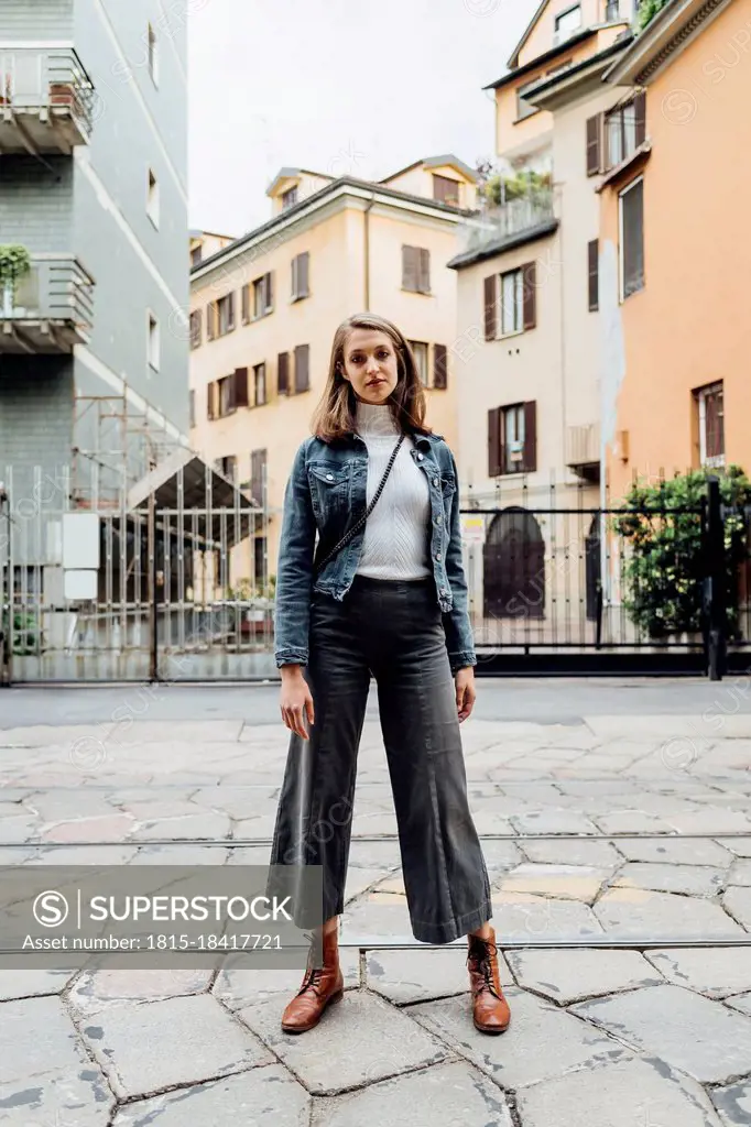 Young woman staring while standing at city street