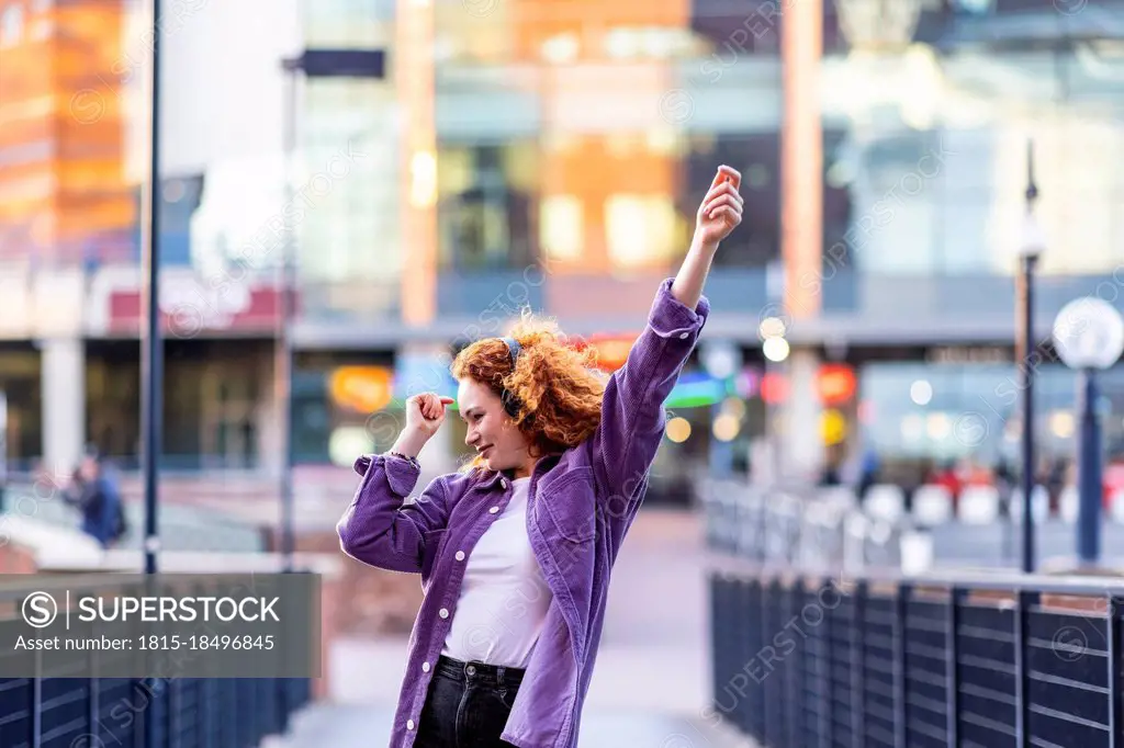 Young woman dancing on bridge during sunset