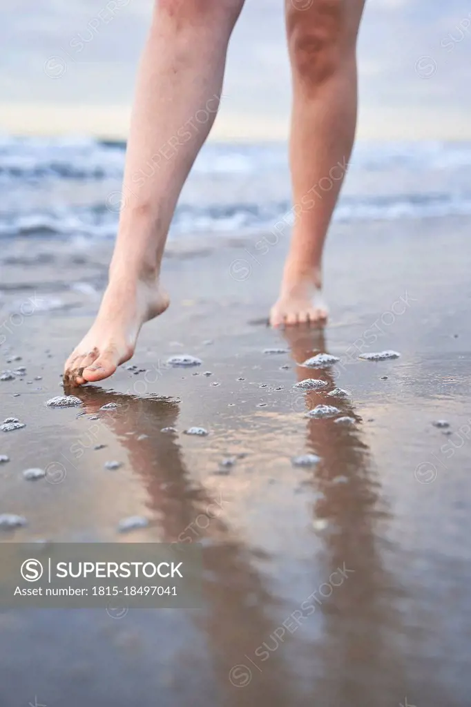 Young woman walking at water's edge