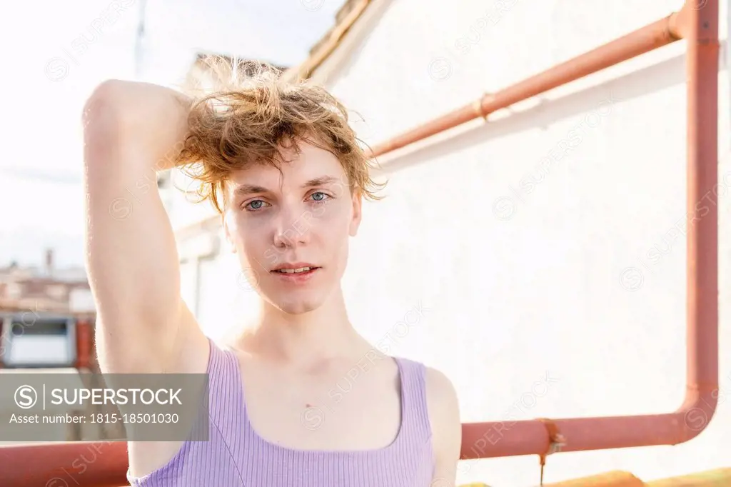 Gay man with hand in hair on building terrace