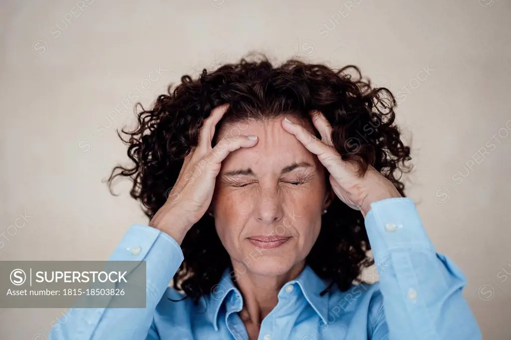 Exhausted businesswoman grimacing with headache