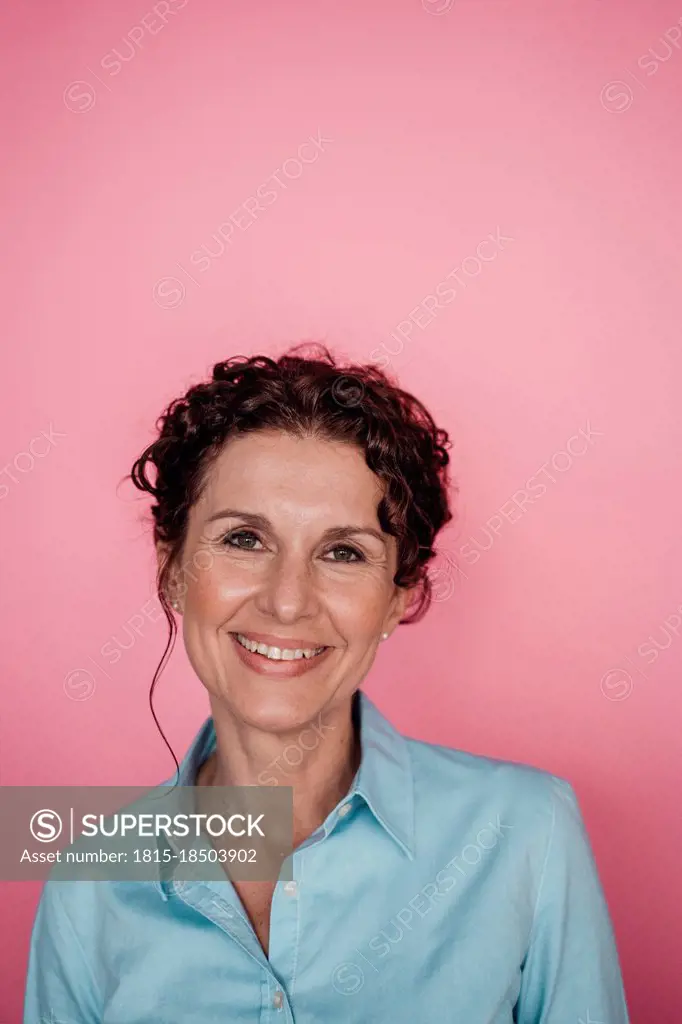 Smiling businesswoman over pink background