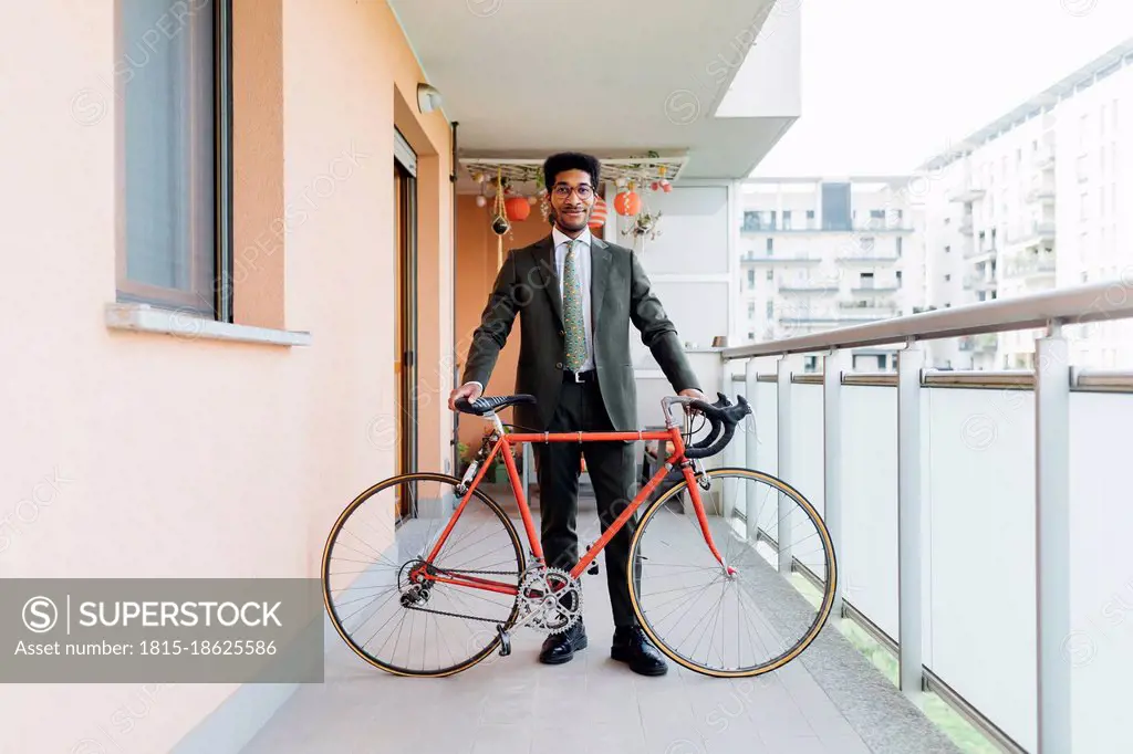 Businessman standing with bicycle at balcony