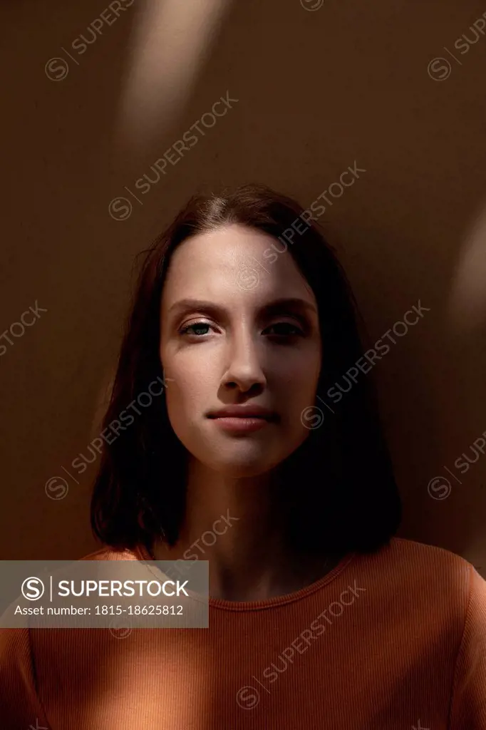 Young woman staring in front of wall