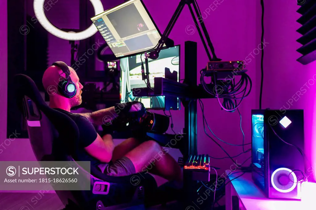 Male gamer playing video game at studio