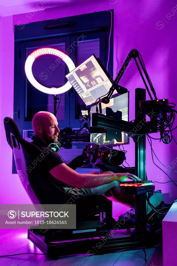 Bald male gamer playing video game at studio