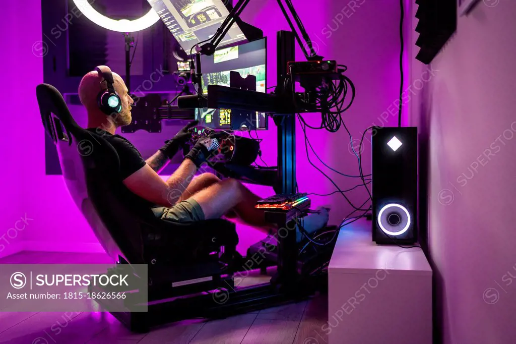 Man playing video game while sitting on chair at studio