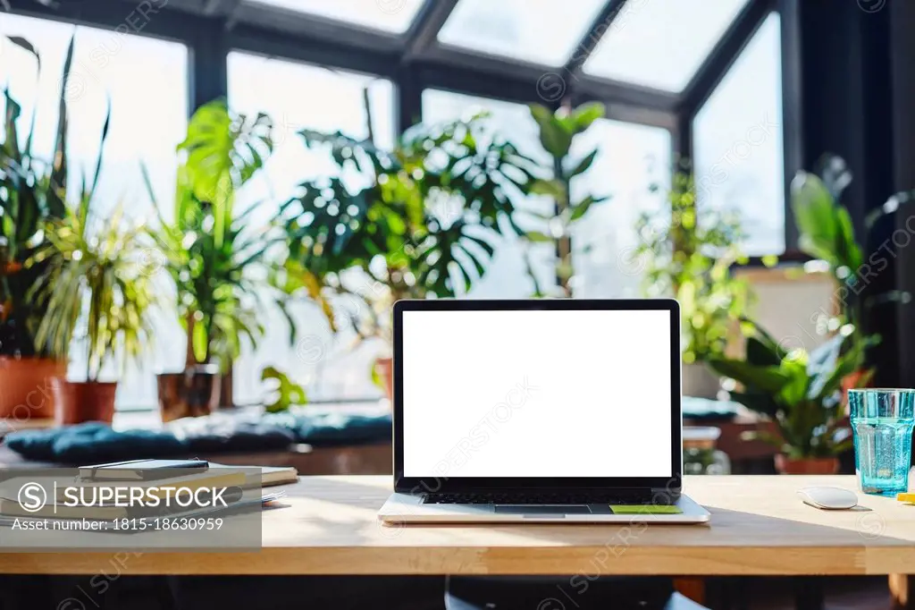 Laptop and diaries on desk in office