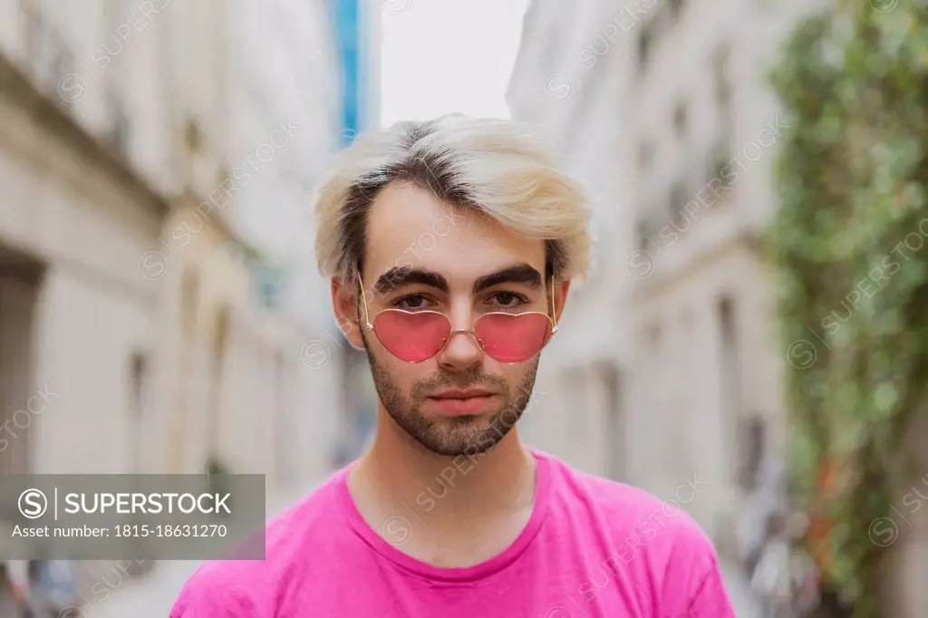 Young gay man wearing heart shaped pink sunglasses