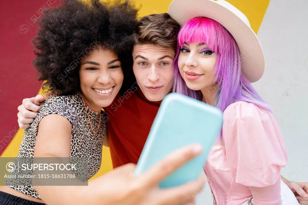 Smiling Afro woman taking selfie with friends