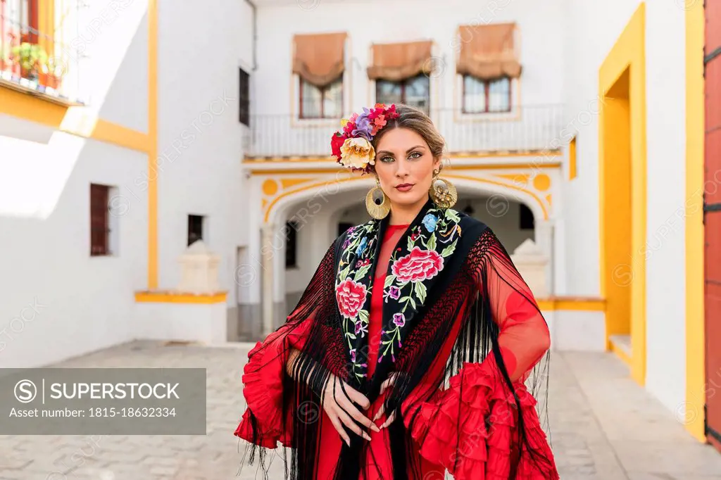 Woman in traditional dress standing at Plaza de toros de la Real Maestranza de Caballeria de Sevilla, Spain