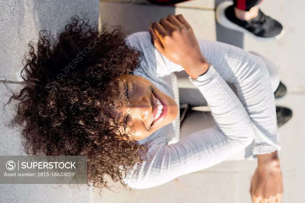 Young afro woman sitting on steps