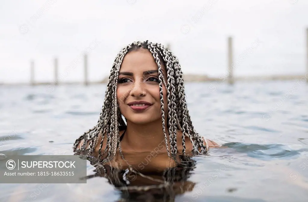 Smiling woman enjoying in water during weekend