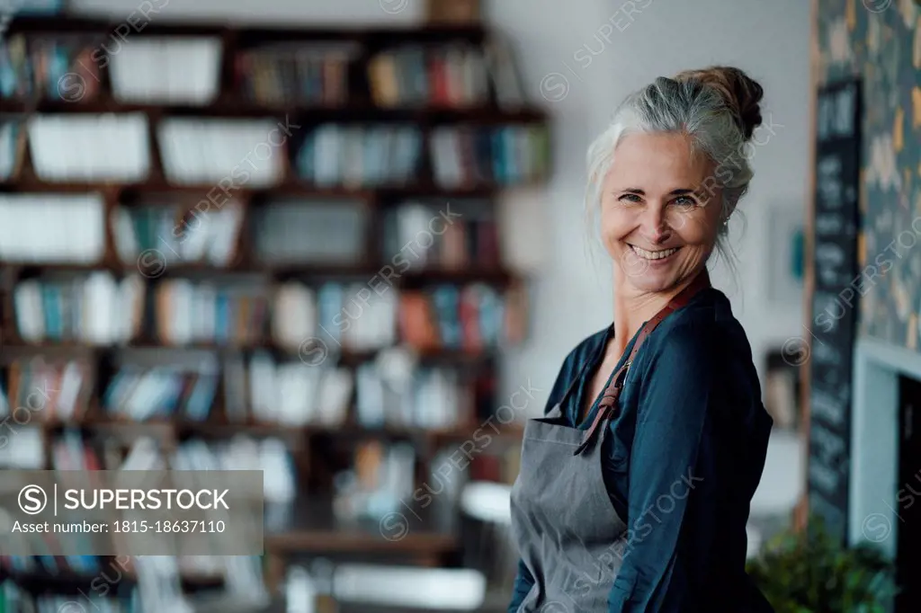 Happy female entrepreneur in coffee shop