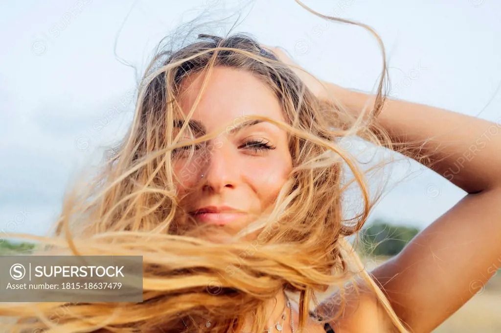 Beautiful young woman with hand in hair