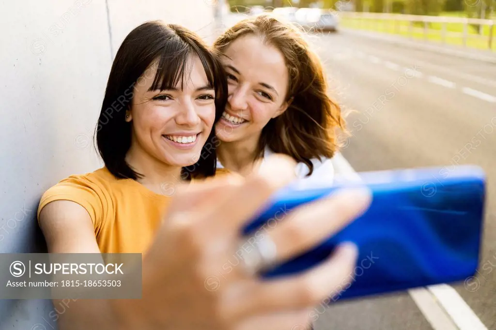 Lesbian couple taking selfie through mobile phone