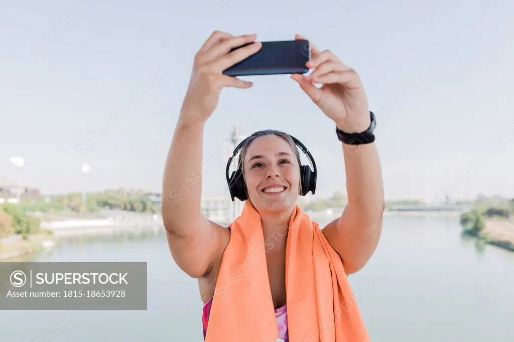 Young female athlete taking selfie through smart phone