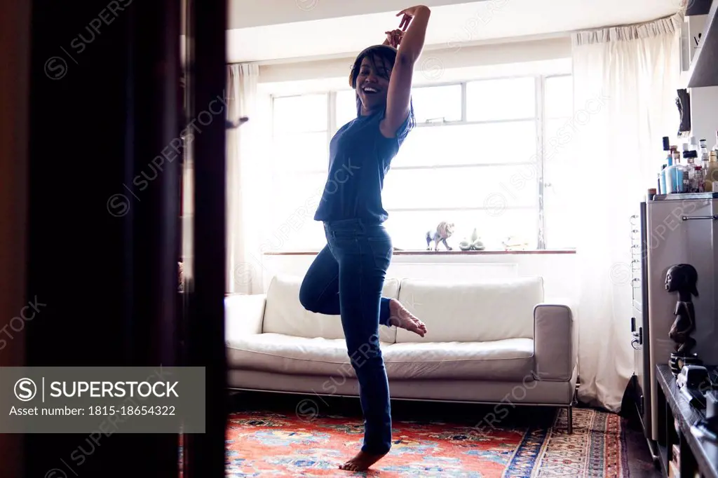 Cheerful woman dancing at home